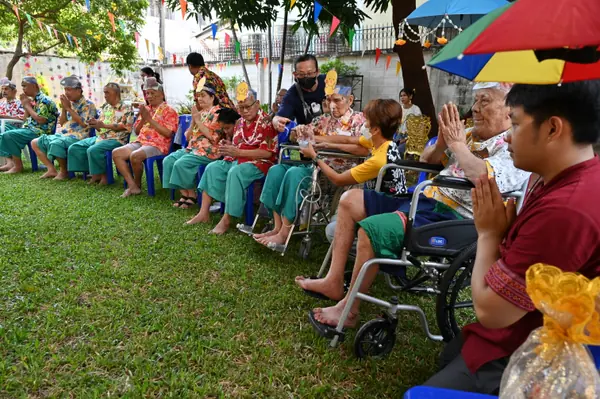 ผู้สูงอายุนั่งรถเข็นเข้าร่วมกิจกรรม